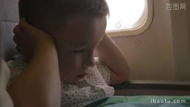 紧张的小孩坐在飞机上，用手捂住耳朵，因为飞机的噪音和恐惧